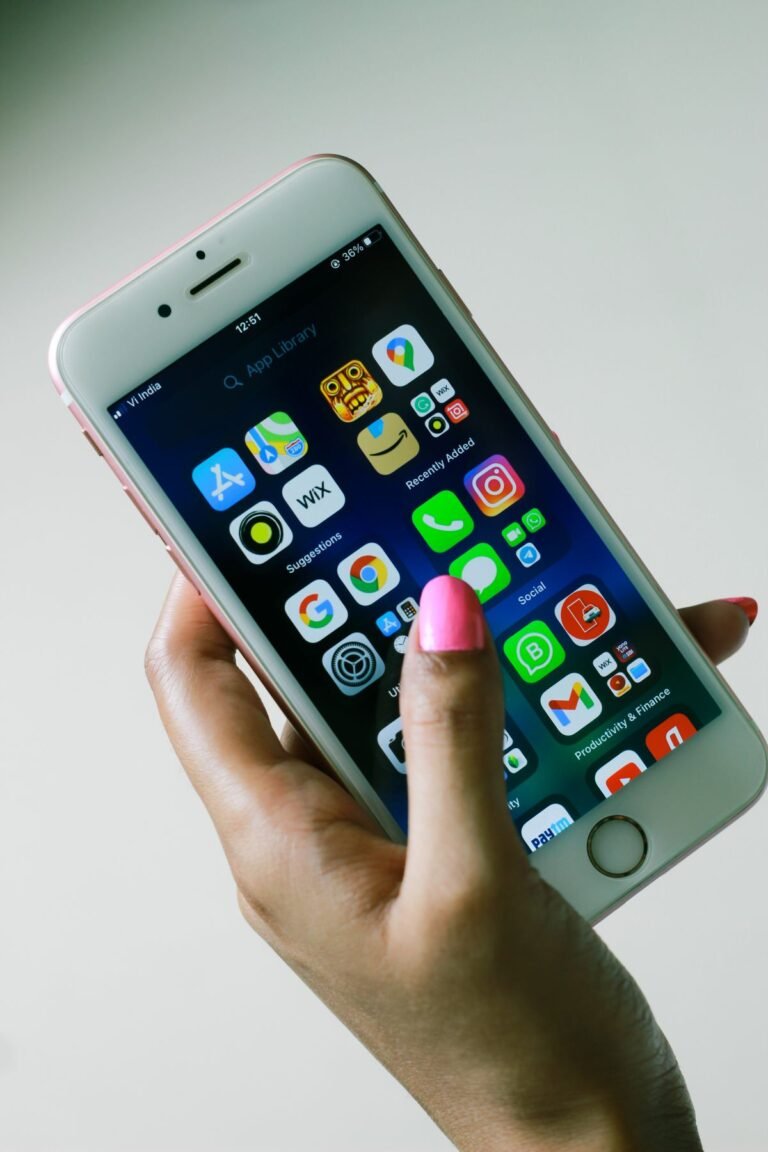 Hand holding a smartphone showing app icons